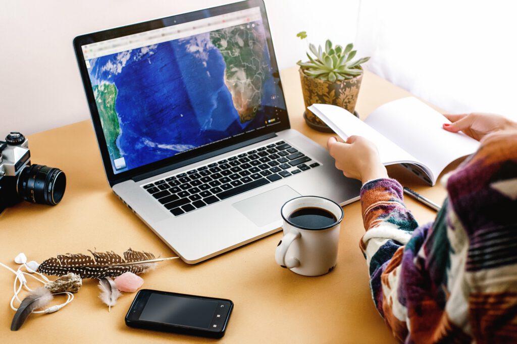 stylish girl with coffee on background of laptop map